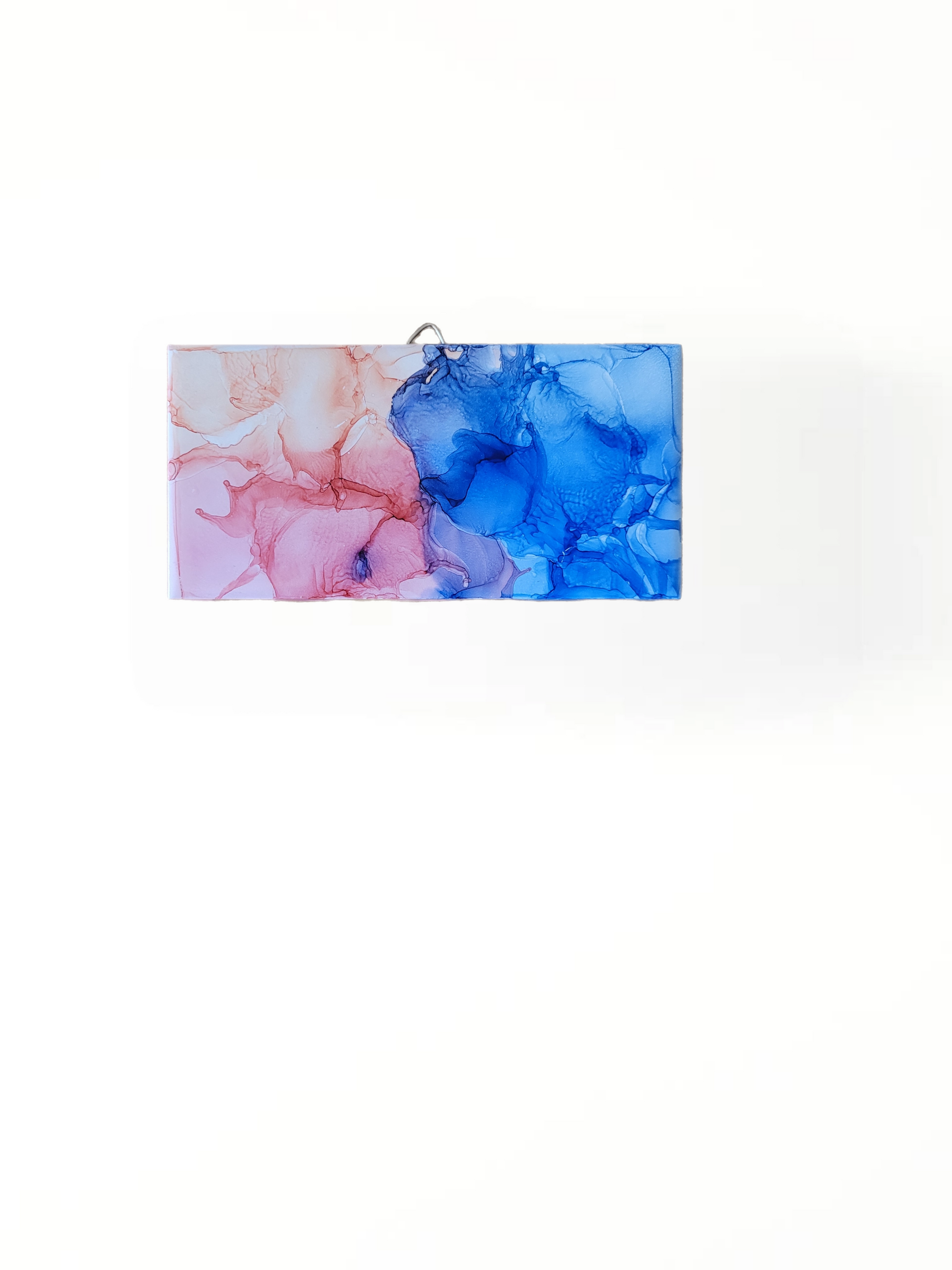 Abstract art on a 3 x 6-inch ceramic tile with a mix of blue and pink colors. 