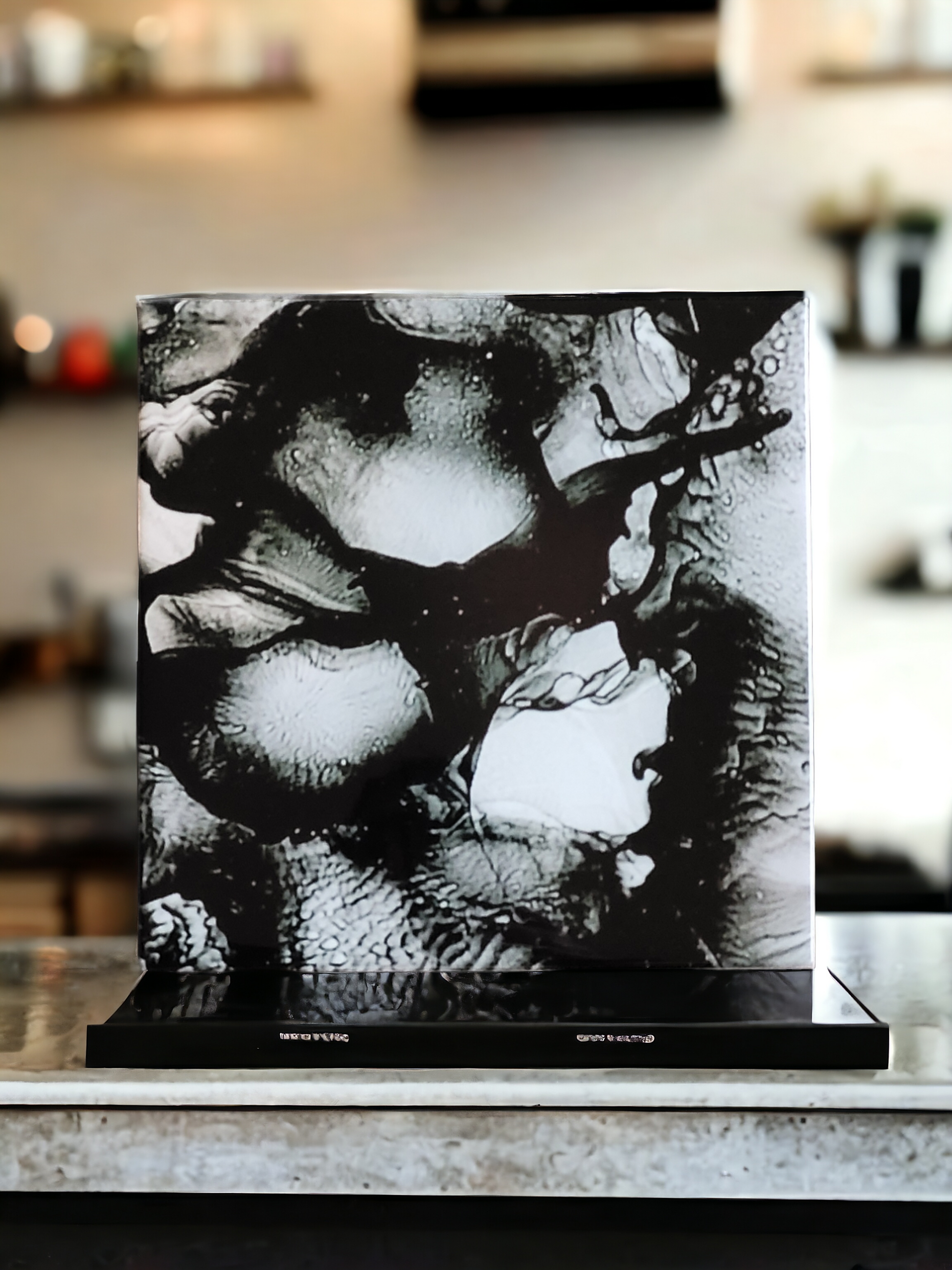 8x 8-inch ceramic tile alcohol ink art display that is an abstract design using the color black and the sublimation process. 