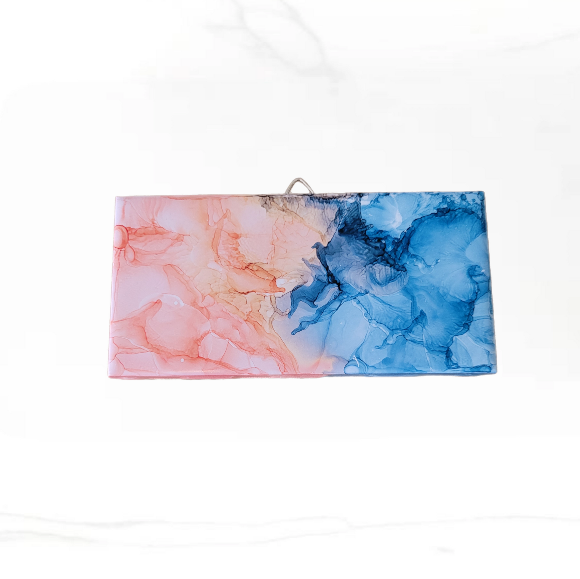 Abstract art on a 3 x 6-inch ceramic tile with a mix of blue and pink colors. 