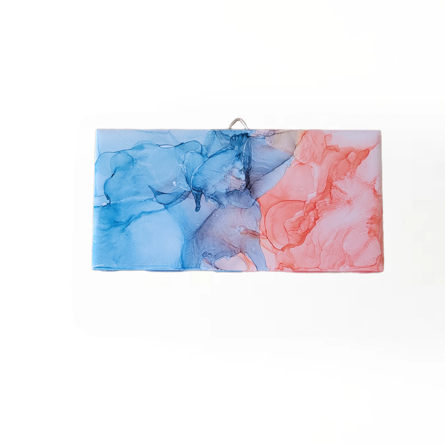 Abstract art on a 3 x 6-inch ceramic tile with a mix of blue and pink colors. 