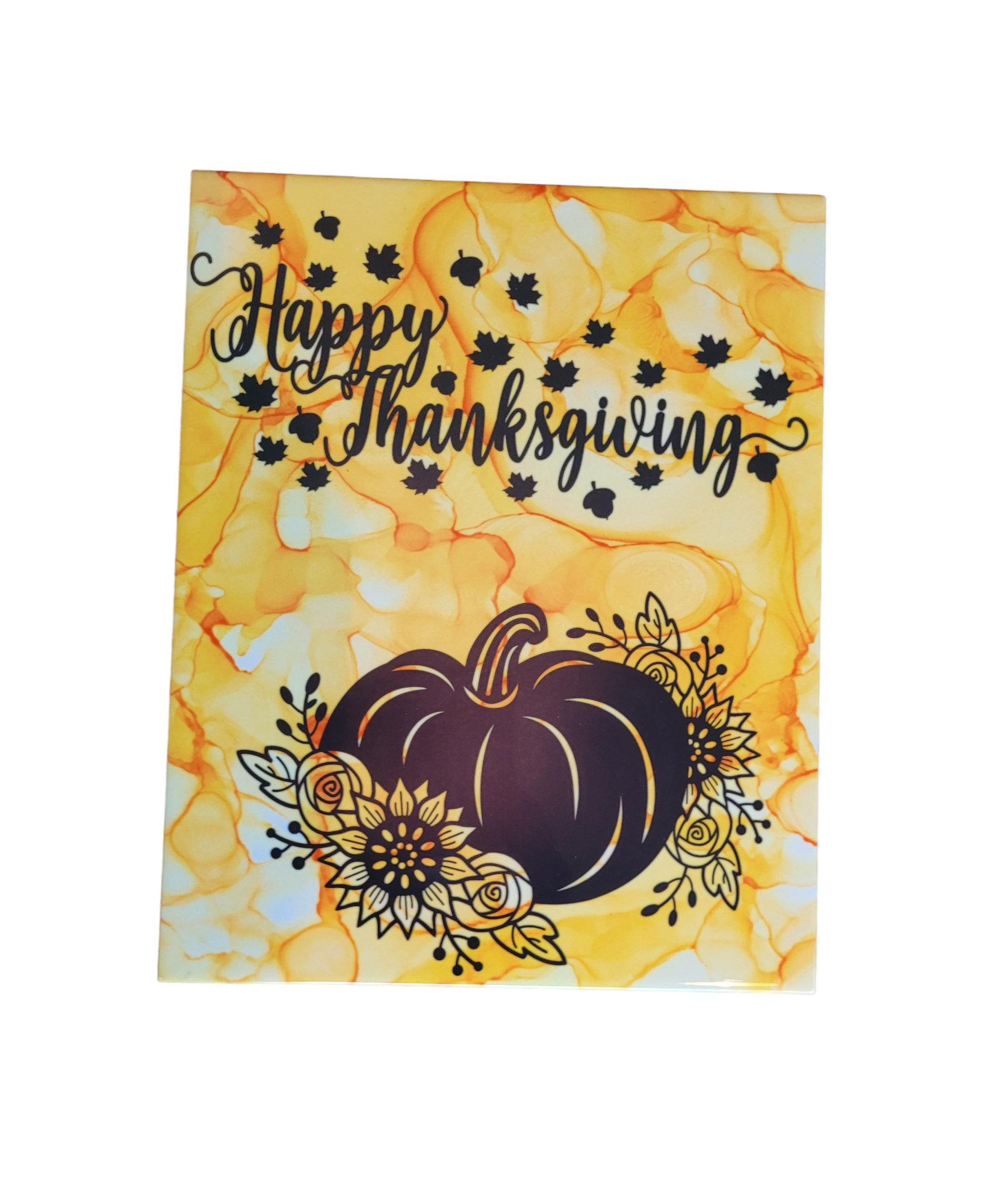 An 8 X 10-inch ceramic tile plaque with a yellowish-gold color alcohol ink background that has the words "Happy Thanksgiving" in black print with small black leaves around the words and a pumpkin at the bottom with Fall flowers