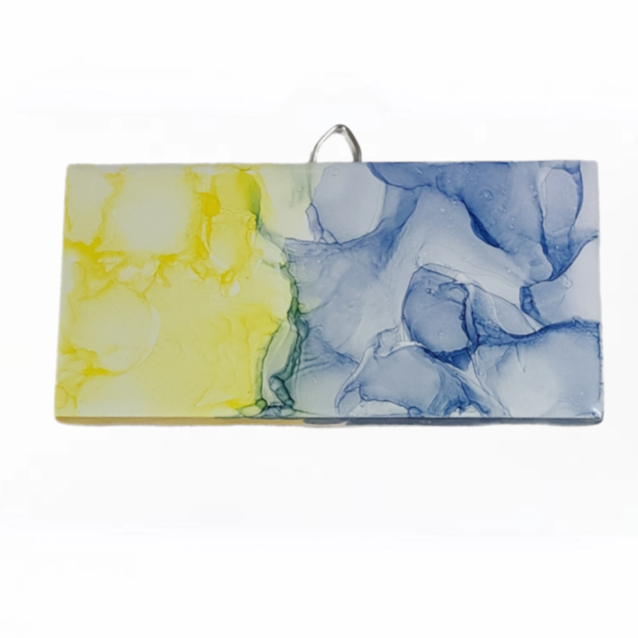 Abstract art on a 3 x 6-inch ceramic tile with a mix of blue and yellow colors. 